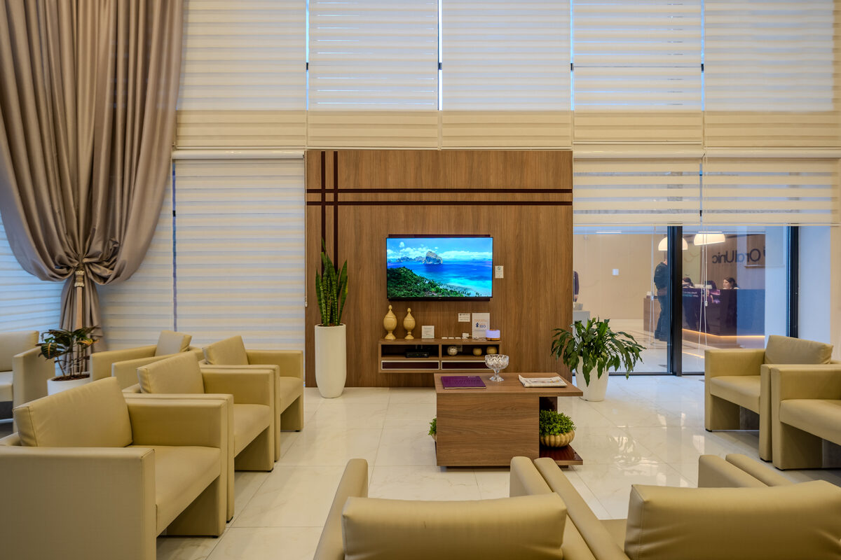 Sala de espera da Oral Unic Caxias do Sul com poltronas e pé-direito duplo